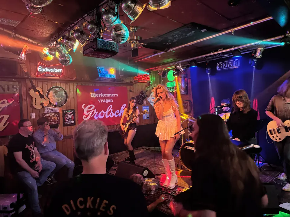 Een blonde zangeres in een glinsterend jurkje en een band in het gezellige Café De Cactus